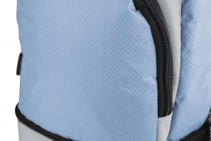 Nahaufnahme der Seitenansicht eines silber-blauen COOL*SAFE-Rucksacks. Sichtbar ist die strukturierte, leicht glänzende Oberfläche sowie ein seitlicher Reißverschluss, der in ein isoliertes Fach führt.