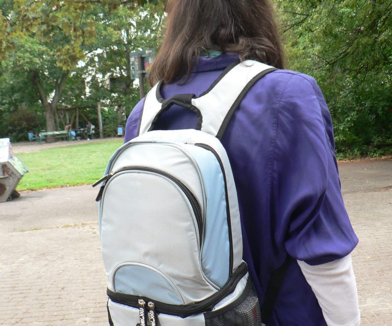 Person von hinten mit einer COOL*SAFE Medikamentenkühltasche in Rucksackform beim Spaziergang im Park.