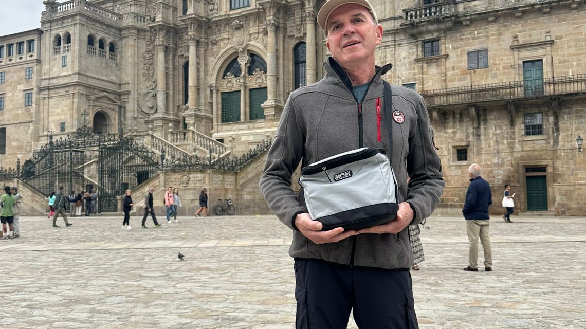 Person steht vor der Kathedrale von Santiago de Compostela und hält eine COOL*SAFE Medikamentenkühltasche in den Händen.